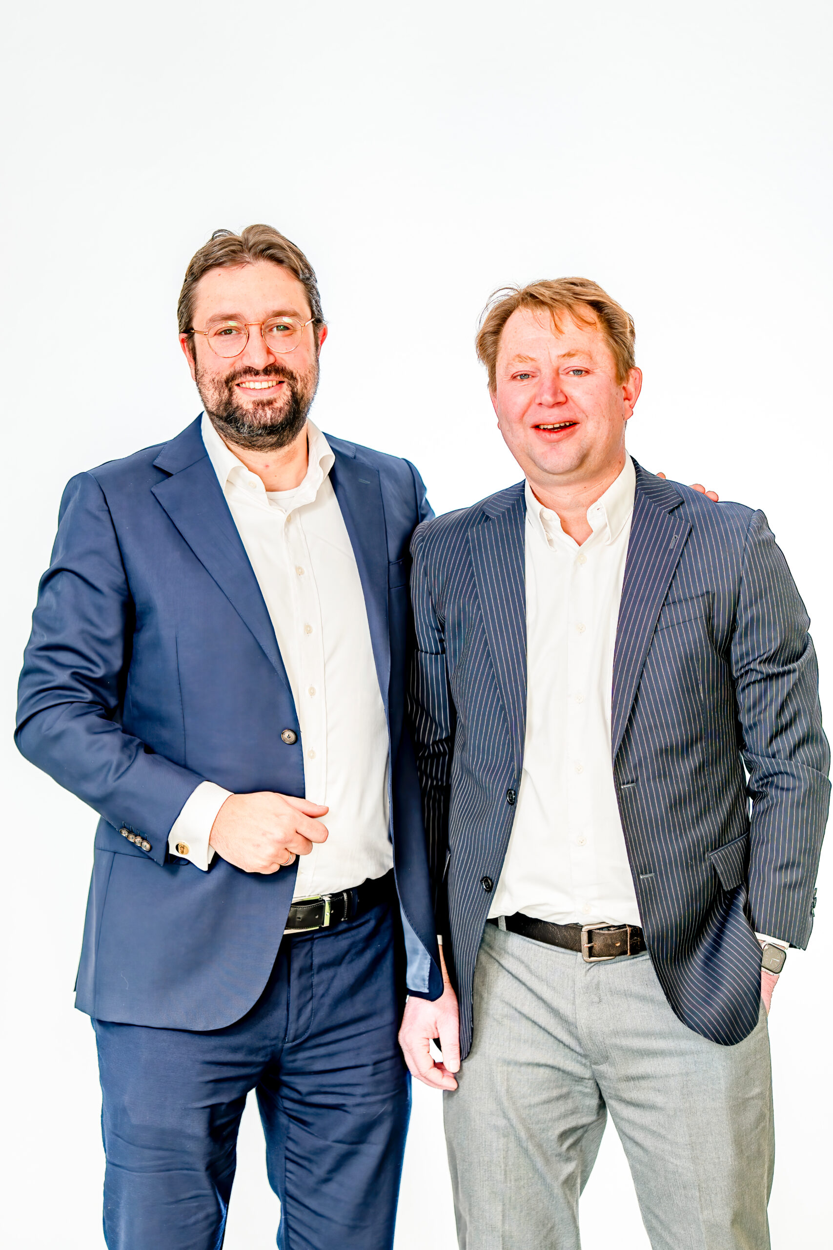 Two Bluem founders in suits smiling side by side