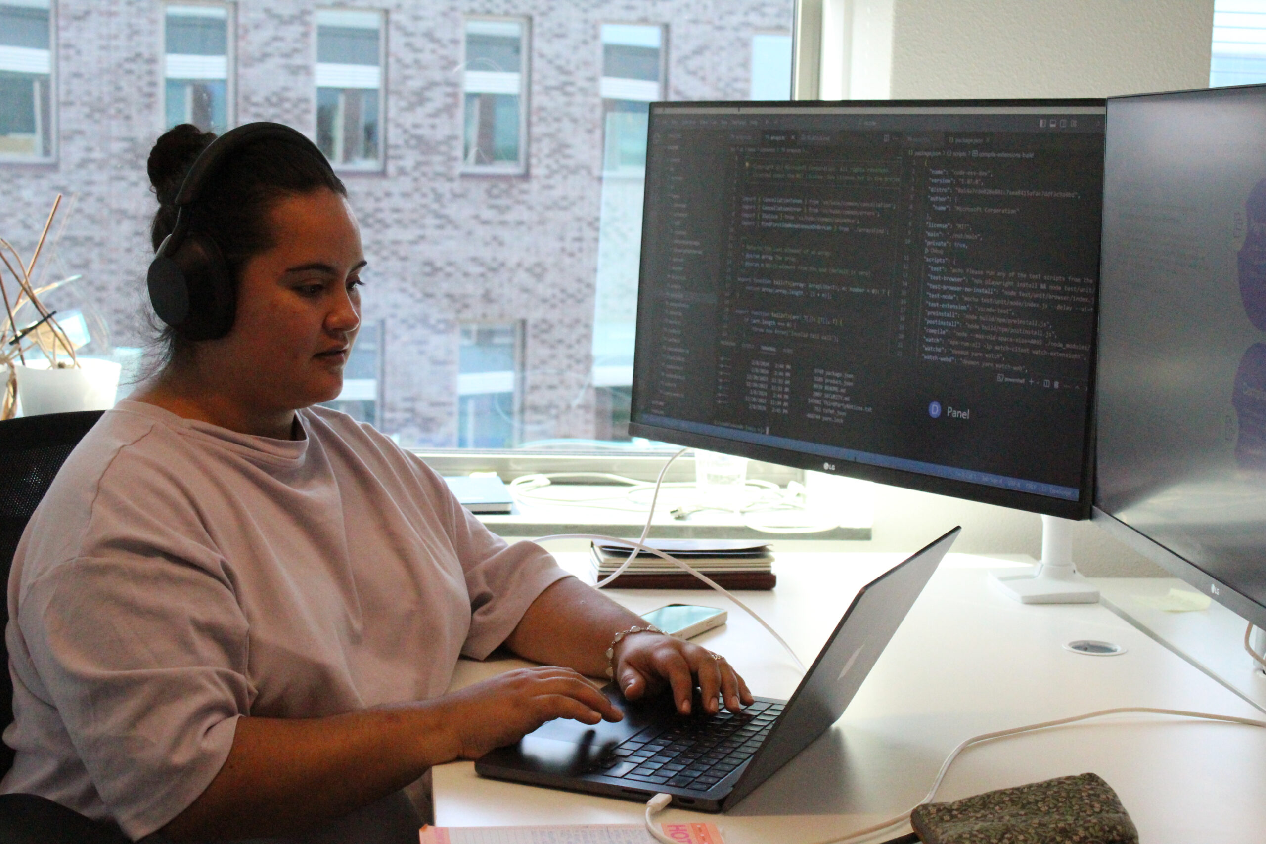 Fraud analyst wearing headphones working at a computer