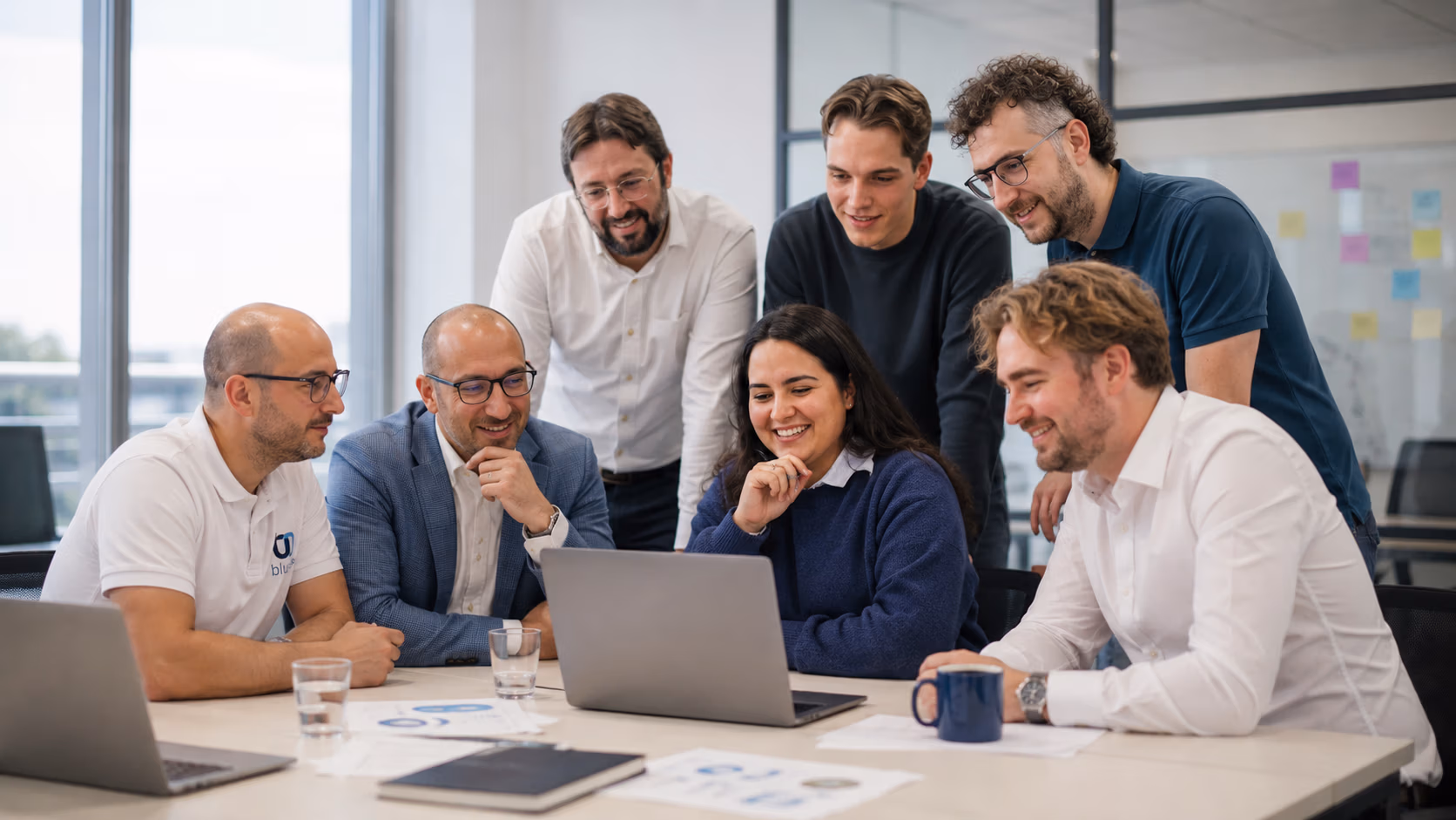Bluem team gathered around a laptop at the Amersfoort headquarters