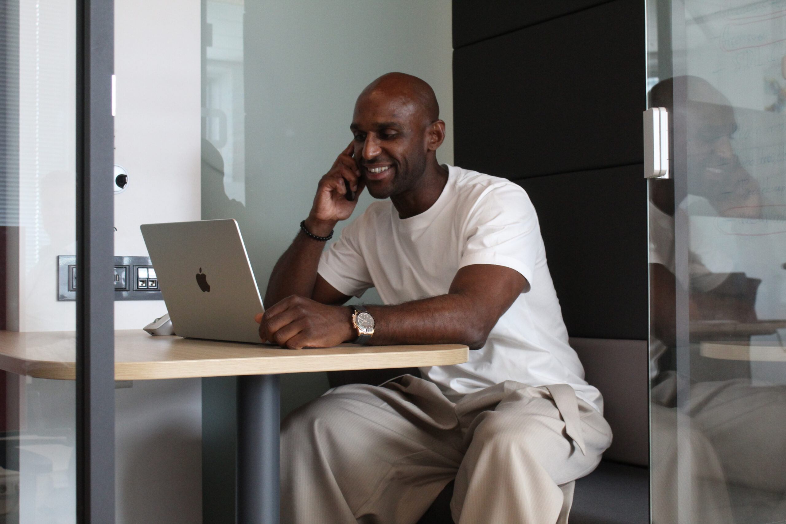 Man on a phone call working on his laptop