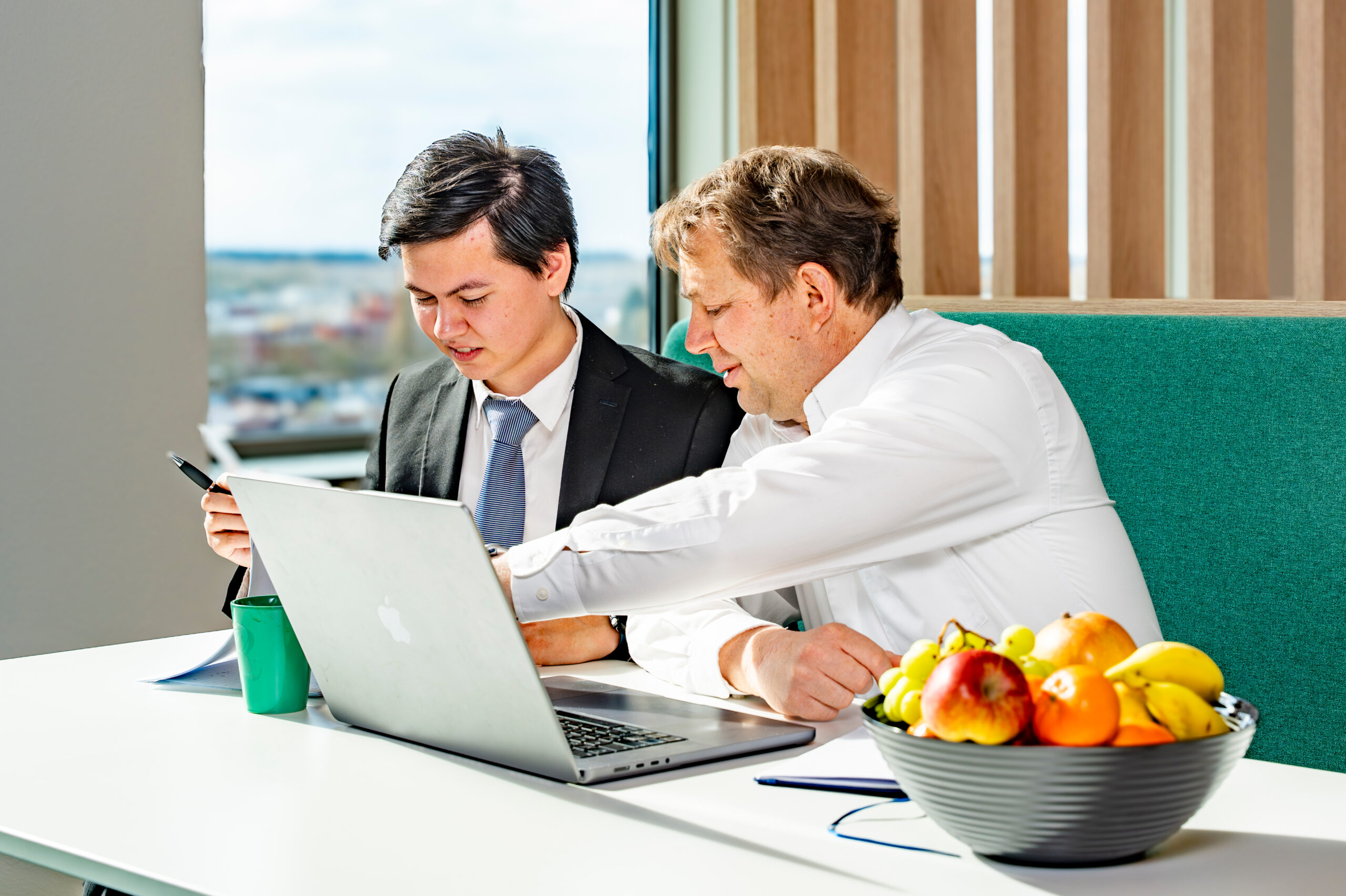 Two colleagues reviewing payments on a laptop