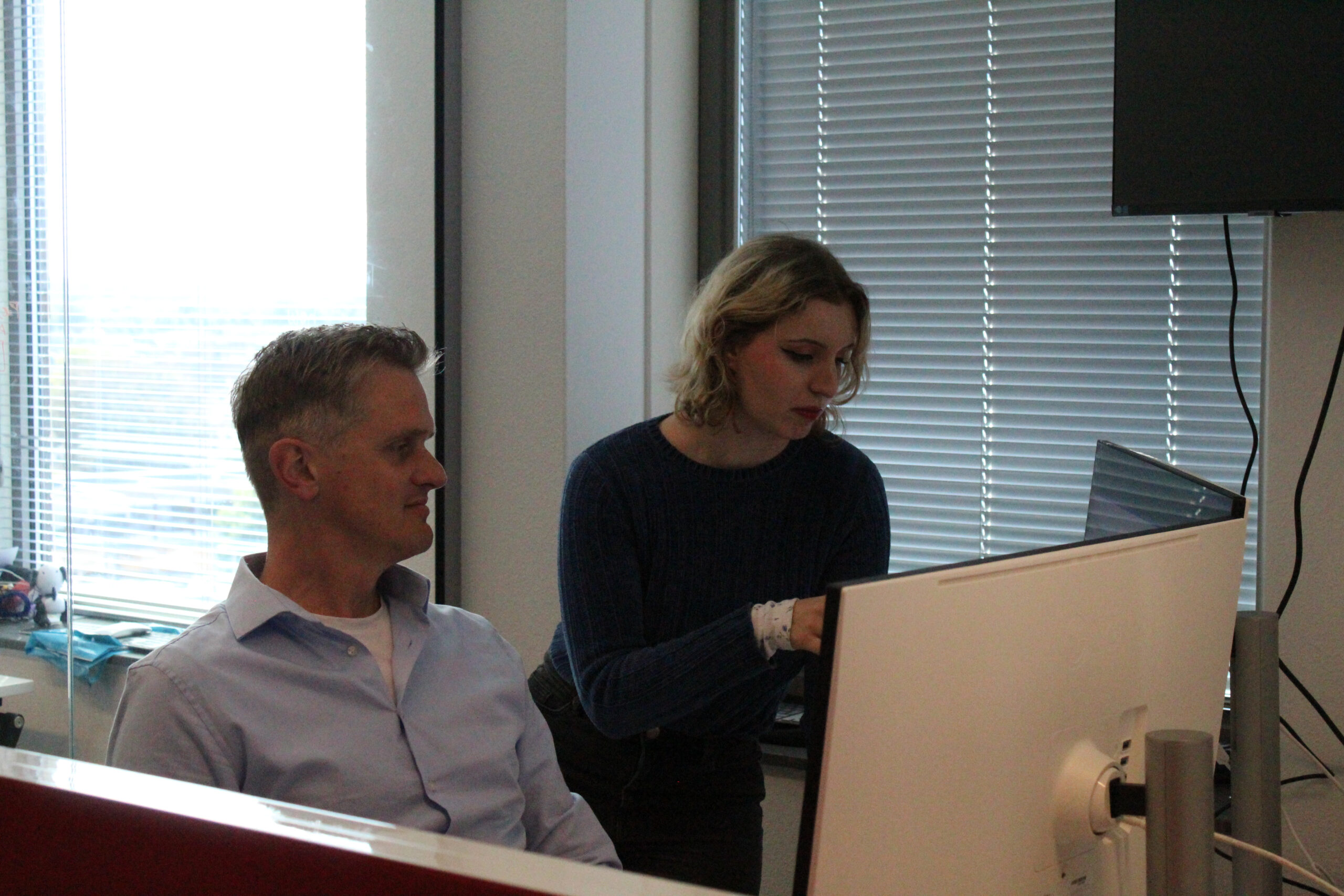 Two colleagues reviewing verification results at a monitor